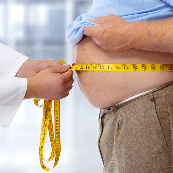 Obese boy who is overweight on a pink background.